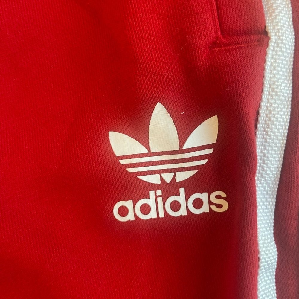 Adidas red track pants with white strips. Cottons fabric